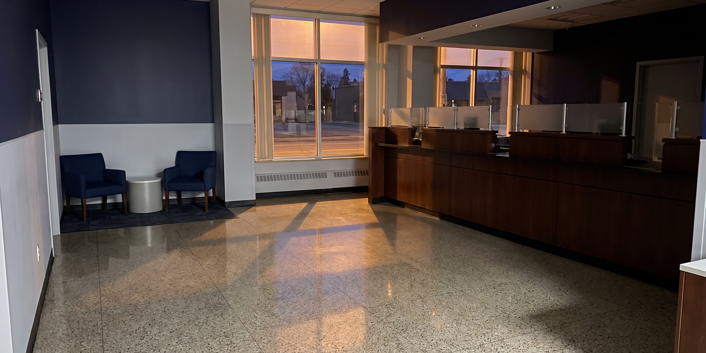 An empty bank branch lobby after hours with a teller counter and a small consultation area.